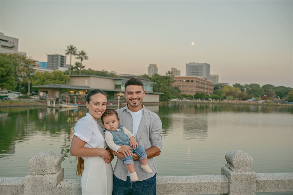 Smiling family holding their baby by the lake at Ohori Park, Fukuoka